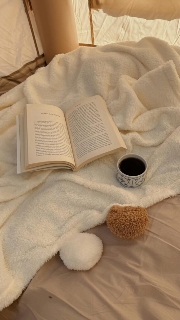 Livre, tassse de café sur un lit douillet.